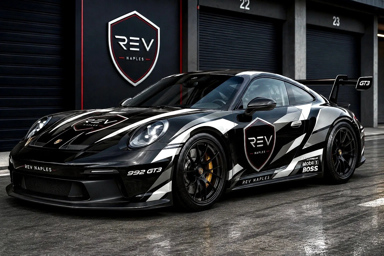 The REV Naples Porsche 992 GT3 in club livery, staged in the pit lane